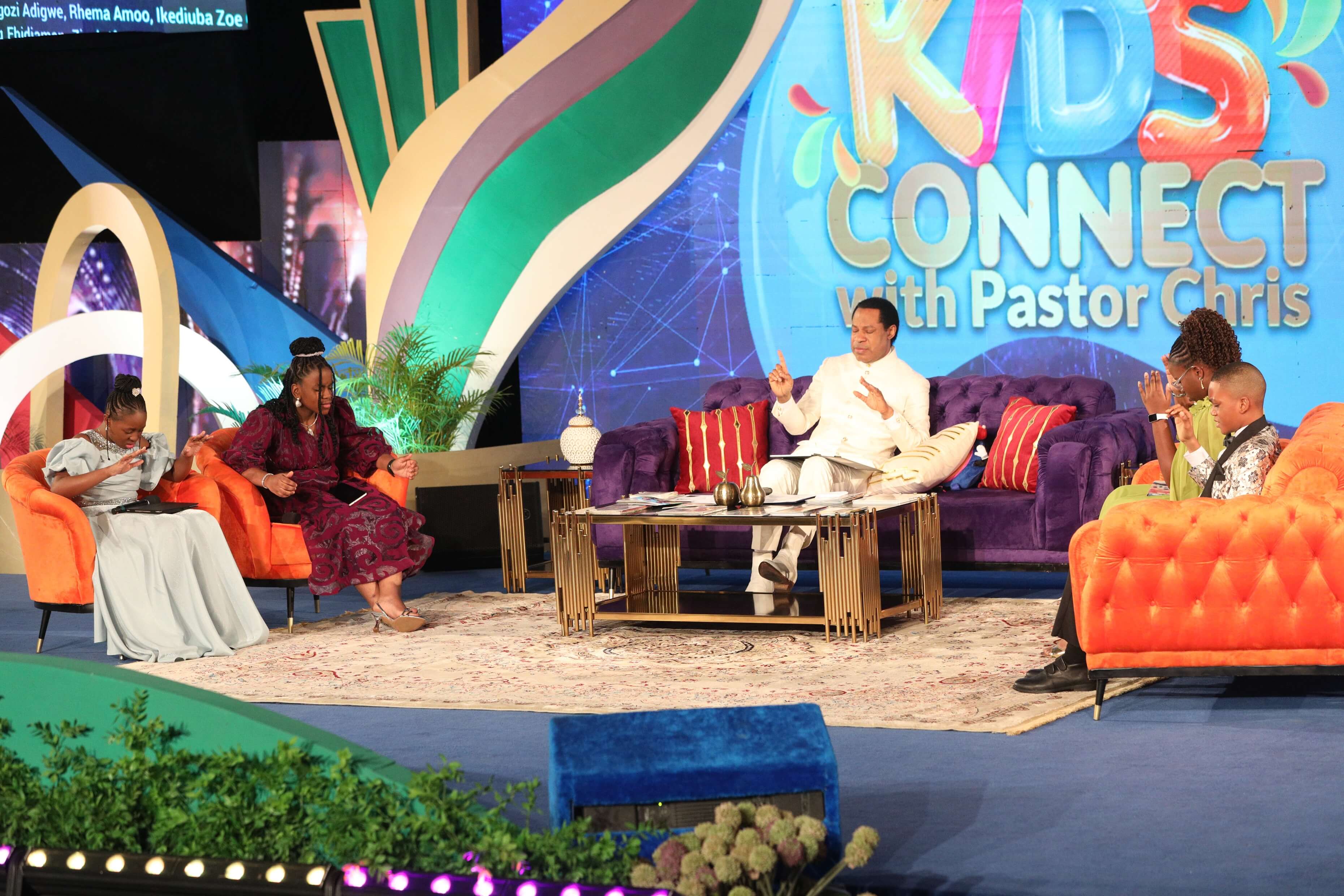 Pastor Chris praying with children on the GKCPC set